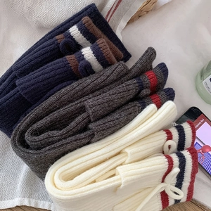 Detail of ribbed knit leg warmers with bows and stripes in navy, grey and white