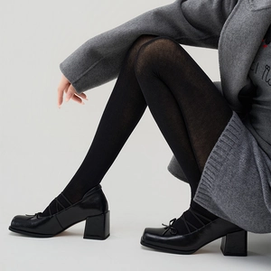 Close-up of black Mary Jane chunky heels with bow detail and crossed straps