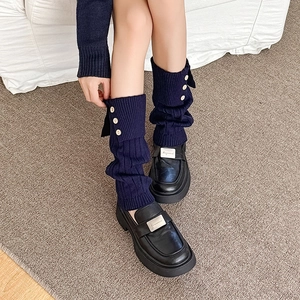 Navy blue ribbed leg warmers with side buttons paired with black platform loafers shoes