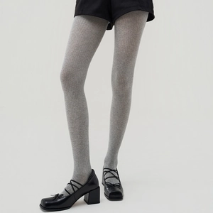 Detailed view of grey vertical ribbed tights paired with black shorts and Mary Janes