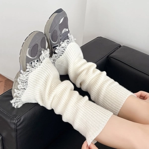 Detail of white ribbed knit leg warmers with grey fringe trim and textured flare design