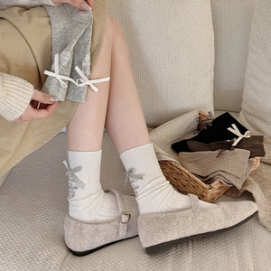 Detail of ribbed crew socks featuring a 3D ribbon bow and happiness heart embroidery