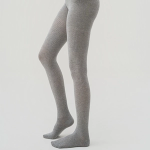 Detailed view of grey vertical ribbed knit tights on model for a slim fit appearance