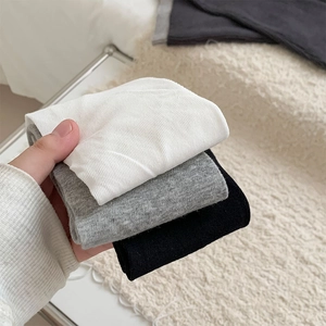 Detail of ribbed knit texture on white, gray and black split toe calf socks