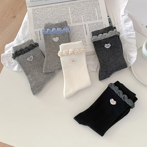 Detailed view of ruffled cuffs and heart patches on five colors of mid-calf socks