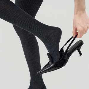 Detail of dark grey vertical ribbed knit tights showing premium elastic fabric texture
