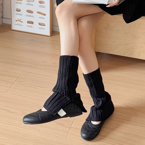 Black ribbed knit leg warmers paired with quilted ballet flats for autumn warmth