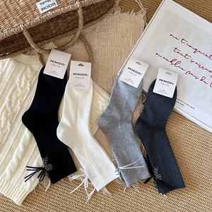 Detail showing grey ribbed socks with sparkling rhinestone heart and silk bow accent