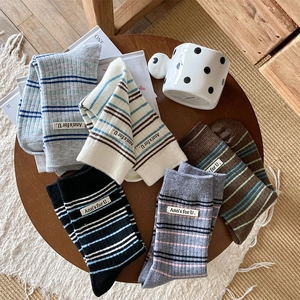 Détail de chaussettes rayées en cinq couleurs avec étiquette sur table en bois
