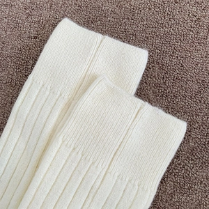 Close-up of thick white ribbed knit texture showing high-density stitching and elasticity