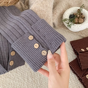 Detail of ribbed knit leg warmers with vintage wood buttons in grey-blue and brown