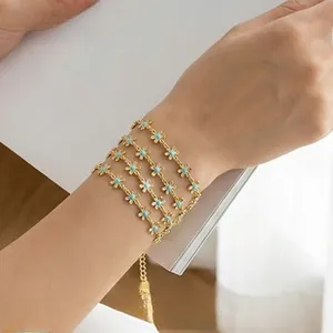 Detailed shot of gold flower link bracelet with turquoise blue beads on wrist