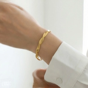 Polished gold twisted rope cuff bracelet shown on wrist for a minimalist jewelry look