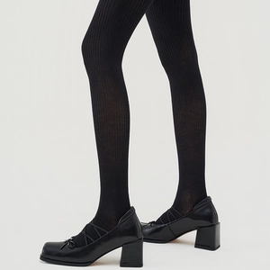 Detail of black vertical striped tights paired with leather Mary Jane chunky heels