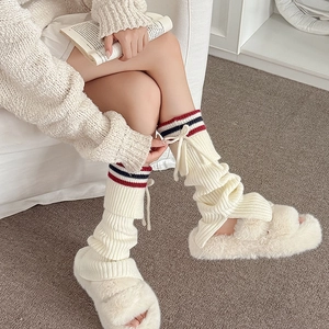 Knitted leg warmers with red and blue stripes and bow ribbon details in ivory white color