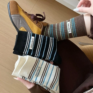 Détail de chaussettes en cachemire à rayures avec étiquettes et poignets côtelés