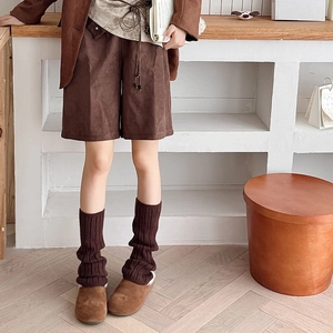 Detailed texture of thick dark brown ribbed knit leg warmers for autumn fashion styling