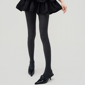 Close-up of dark grey vertical striped knit tights paired with black pointed heels