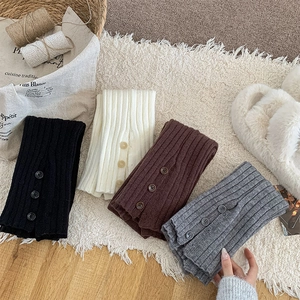 Detailed knit texture of ribbed leg warmers featuring decorative side buttons in four colors