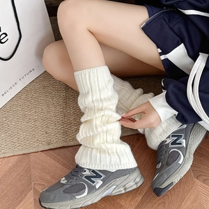Close-up of white vertical striped knitted leg warmers with soft elastic texture