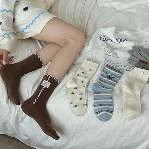 Détail de chaussettes à fleurs douces avec bords volantés et broderie pingouin