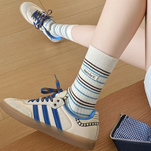 Gros plan détaillé de chaussettes en cachemire rayées avec étiquette vintage en tissu doux