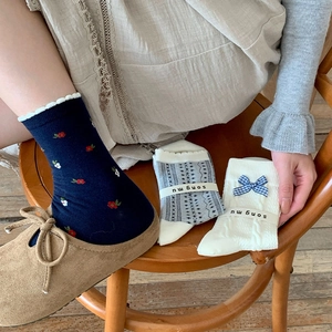 Gros plan détaillé d'une chaussette bleue à fleurs portée avec une chaussure en daim
