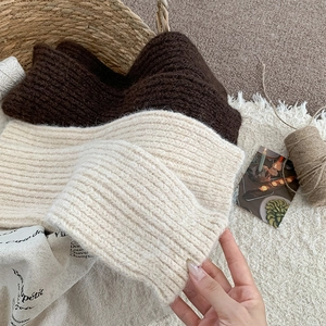 Close-up of thick ribbed knit texture in white and dark brown for winter leg warmers