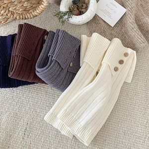 Close-up of ribbed knit leg warmers with wooden buttons in four winter colors