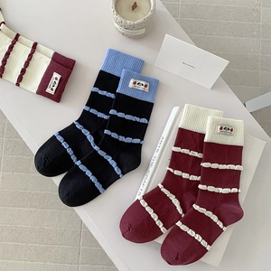 Close-up of ribbed cotton socks with textured stripes and cartoon logo labels