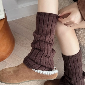 Close-up of dark coffee ribbed knit leg warmers showing thick texture and soft wool material