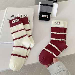 Detail of cotton crew socks with striped patterns and cute cartoon embroidered patches