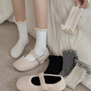 Détail de chaussettes à côtes verticales avec bords ondulés et chaussures Mary Jane