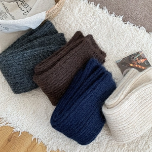 Close-up of thick ribbed knit texture in grey, brown, navy, and cream white shades