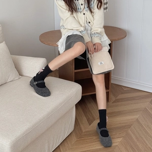 Detailed texture of grey woolen Mary Jane flat shoes with a classic buckle strap design