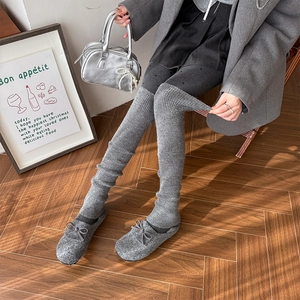 Detail of grey ribbed knit leg warmers worn over knee with stylish polka dot tights