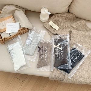 Set of five mid-calf socks in earthy tones with bow details and individual zip packaging