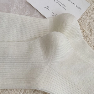 Close-up of white ribbed knit socks showing high-quality stitching and soft texture
