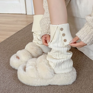 Detail of white ribbed leg warmers with button accents and cozy plush slippers