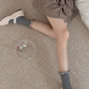 Texture détaillée de chaussettes en tricot côtelé gris foncé avec bords à volants doux