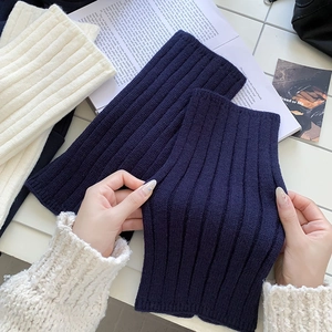 Close-up of ribbed knit leg warmers showing elastic texture and soft cream fabric