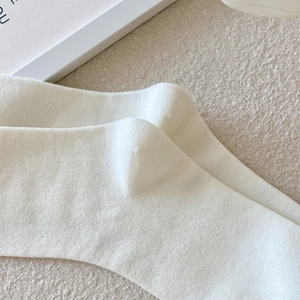Macro shot of white ribbed knit cotton socks showing detailed vertical texture and stitching