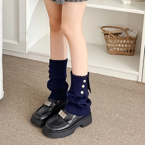 Navy blue ribbed knit leg warmers with white buttons styled with black loafers