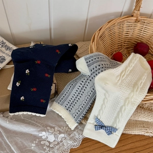 Gros plan de chaussettes mi-mollet à fleurs et nœuds sur un fond vintage chaleureux