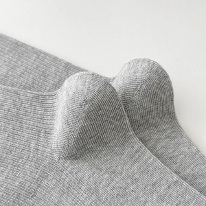 Vue macro de chaussettes en maille côtelée grise avec détail du talon et de la texture
