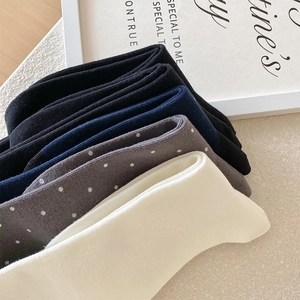 Close-up of cotton mid-calf socks showing ribbed cuffs and polka dot texture details