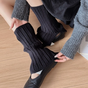 Close-up of black ribbed knit leg warmers showing thick texture and slit detail