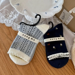 Détails de chaussettes avec broderies florales, jacquard et bords à volants doux