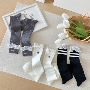 Three pairs of lace trim calf socks with embroidery on light textured carpet
