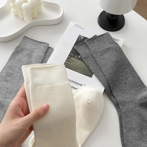 Texture de tricot détaillée des chaussettes à côtes verticales en gris foncé, gris et beige